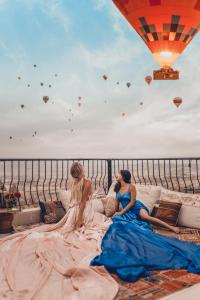 乌奇希萨尔Mak's Cave House的坐在带热气球的沙发上的新娘和新郎