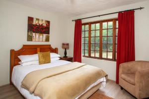 马加利斯堡Whispering Pines Country Estate的卧室配有床、椅子和窗户。