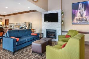 辛辛那提Comfort Inn & Suites的客厅配有沙发、两把椅子和壁炉