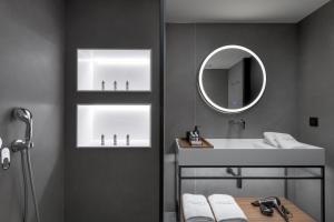 罗德镇Essence Suites Downtown Suites - Adults Only的一间带水槽和镜子的浴室