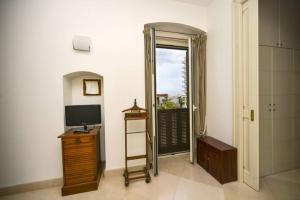 巴里Scesa San Michele的一间配有电视的房间和通往阳台的门