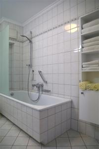 宾茨K & R Appartements Binz的白色的浴室设有浴缸和淋浴。