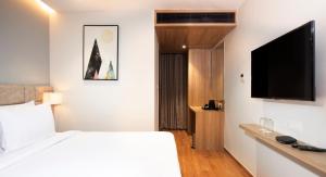 维沙卡帕特南Northway Hotel的配有一张床和一台平面电视的酒店客房