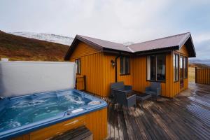塞济斯菲厄泽兰戈希尔德小屋及热水浴池度假屋的房屋旁甲板上的热水浴池