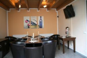 齐陶兹托尔霍夫酒店的餐厅设有黑色椅子和一张桌子,并提供一瓶葡萄酒