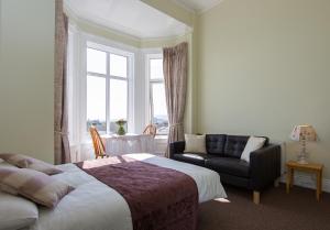都柏林格伦考特公寓的一间卧室配有一张床、一张沙发和一个窗口