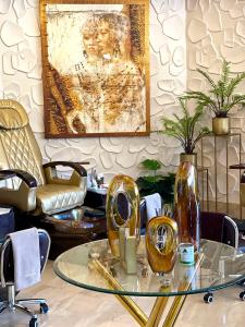 哈拉雷Masawara Urban Retreat的一间房间,上面有一张玻璃桌和两颗金花瓶