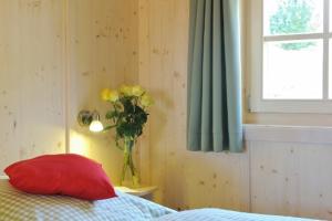 里姆斯廷格兰姆朴洛夫度假屋的卧室配有红色枕头和黄色花瓶