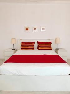 塔维拉布兰卡住宿加早餐旅馆的白色卧室配有一张带红色枕头的大白色床