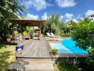 圣弗朗索瓦Villa Aloha的后院设有游泳池和带凉亭的木甲板。