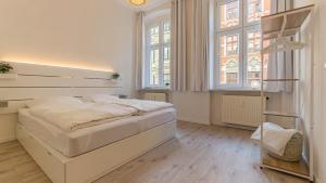 科特布斯CityApartment - 53 m², 2 Zimmer, zentral, Netflix, Küche, Waschmaschine的白色的卧室设有床和窗户