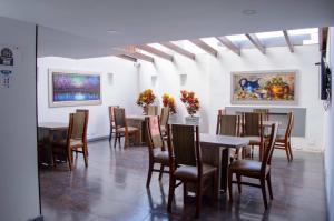 波哥大Hotel Confort 80 Zona Rosa的一间带桌椅和绘画的用餐室