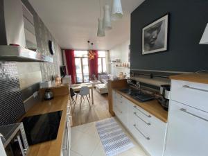 布鲁塞尔Grand Appartement Jourdan EU的厨房配有白色橱柜和黑色墙壁