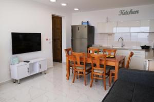迈季代勒舍姆斯SleepWell Suite的厨房配有桌椅和冰箱。