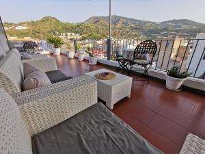 利帕里Lo Nardo Accommodation的阳台配有柳条家具,享有山景。