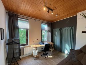 不来梅港Bettchen - Helle charmante Wohnung mit Hochebene的客房设有书桌和2扇窗户。