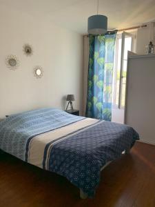 Crouy-sur-CossonLa maisonnée de Chambord的一间卧室配有一张带蓝色毯子的床和窗户。