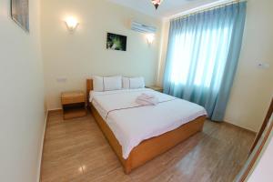 亚喀巴红海潜水中心酒店的一间卧室配有一张带白色床单的床和一扇窗户。