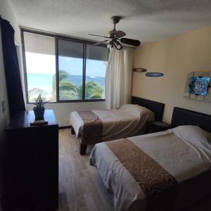 坎昆Bella Beach Condo Vacation 2 bedrooms的酒店客房设有两张床和大窗户。