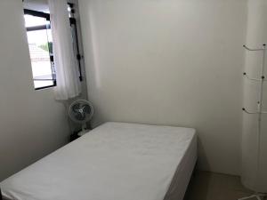 帕罗卡Apartamento Ilha do Coral的一间小卧室,配有白色的床和窗户