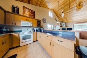 大天空市Firelight Chalet 94的厨房配有木制橱柜和炉灶烤箱。