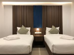 清迈Vista Hotel Chiang Mai - SHA EXTRA PLUS的两间带两张床的酒店客房
