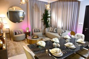 迪拜Smart Living Villa的一间带餐桌的客厅和一间带粉红色墙壁的客厅。