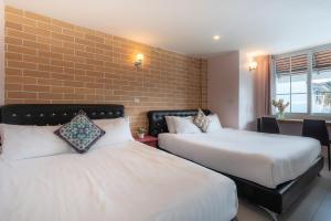 清迈小熊之家旅馆的酒店客房带两张床和砖墙
