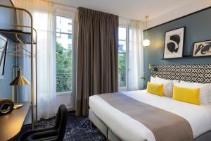 巴黎夏洛特宫殿酒店的酒店客房设有一张床、一张书桌和窗户。