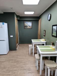 下诺夫哥罗德Ilyinskiy Hostel的一间带2张桌子和冰箱的用餐室