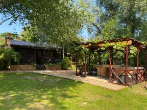 RibchesterLuxury Log Cabin with Outdoor Wood Fired Hot Tub & Pizza Oven的房屋前带凉亭的花园