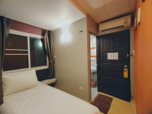 曼谷菩阿提BB旅馆的一间小卧室,配有一张床和一个黑色的门