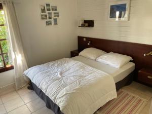 基伯龙Maison Golvan centre ville avec parking et jardin的一间卧室配有一张带白色床单的大床