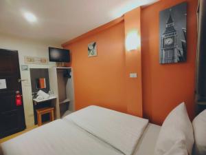 曼谷菩阿提BB旅馆的卧室配有一张床,墙上挂着一个钟