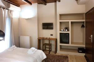 卡拉维塔阿尼西斯酒店的卧室配有白色的床和电视