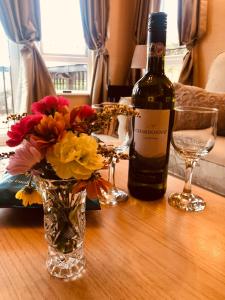 奥克尼Rymmon Retreat的一瓶葡萄酒和一张花瓶在桌子上