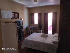 卡诺格布拉达Suítes D'Belinha的一间带床和冰箱的小卧室