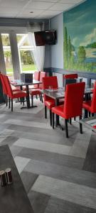 阿尔特奈法斯特奥尔良北阿腾纳酒店的一间用餐室,配有红色的桌椅和绘画作品