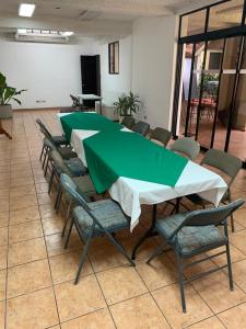 圣萨尔瓦多拉珀萨达德尔安吉酒店的一组桌椅,配有绿色的桌布