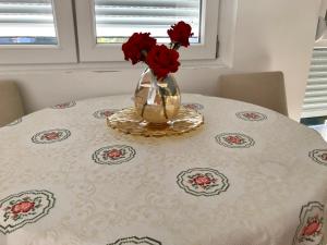 尼克希奇Apartments Premović Nikšić的一张桌子上装着红玫瑰的花瓶