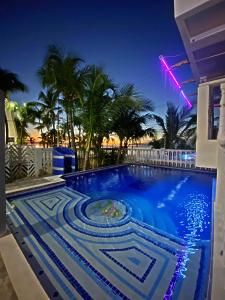 圣安德烈斯Sunset Paradise的棕榈树的夜间游泳池