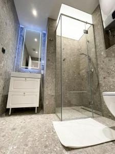 巴尼亚卢卡Premium Apartmani Banja Luka的一间带玻璃淋浴和水槽的浴室
