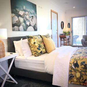 Morisset EastSilverWaters Waterfront Accommodation的一间卧室配有黄色和白色枕头的床