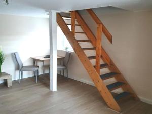弗赖塔尔Apartment in Saxony in a charming area的木楼梯,房间配有桌椅