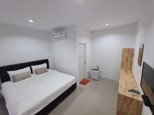 清刊Vamin Resort Chiangkhan Loei วามินทร์รีสอร์ท เชียงคาน เลย的白色卧室配有床和平面电视