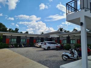 清刊Vamin Resort Chiangkhan Loei วามินทร์รีสอร์ท เชียงคาน เลย的停车场内有车辆的旅馆