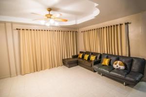 梭桃邑Vanilla house heart of Sattahip的客厅配有带黄色枕头的黑色皮沙发