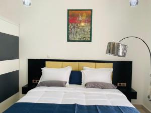 吉布提JANO HOUSE AppartHôtel的一张带两个枕头的床,上面有一张图