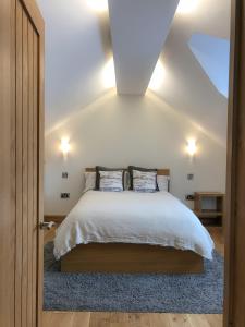 北安普敦The Manor Barn的一间卧室配有一张带白色床单和蓝色地毯的床。