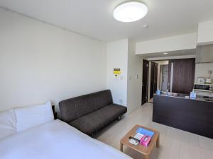 东京CIEL BLEU的一间卧室配有一张床、一张沙发和一张桌子